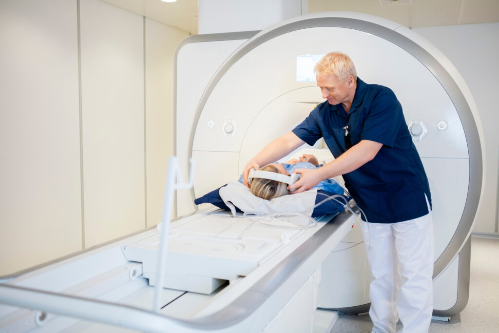 Medical professional positioning a patient for an MRI scan inside a diagnostic imaging machine at a healthcare facility