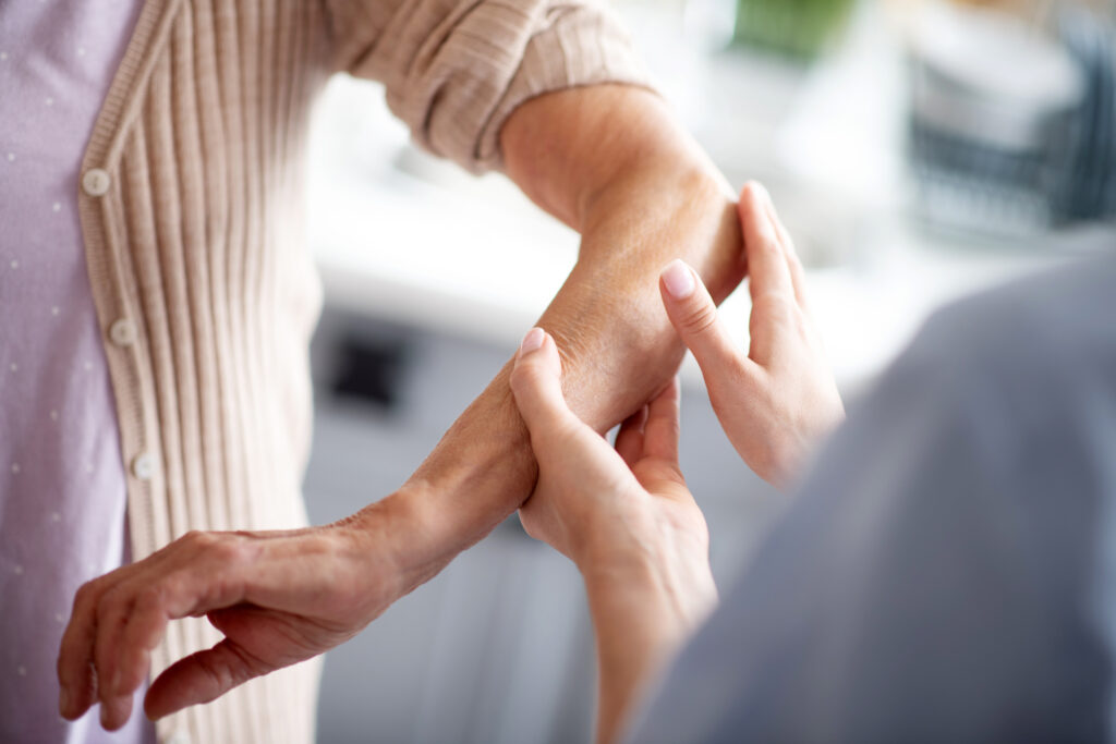 Healthcare professional examining a patient’s forearm and wrist during a medical assessment