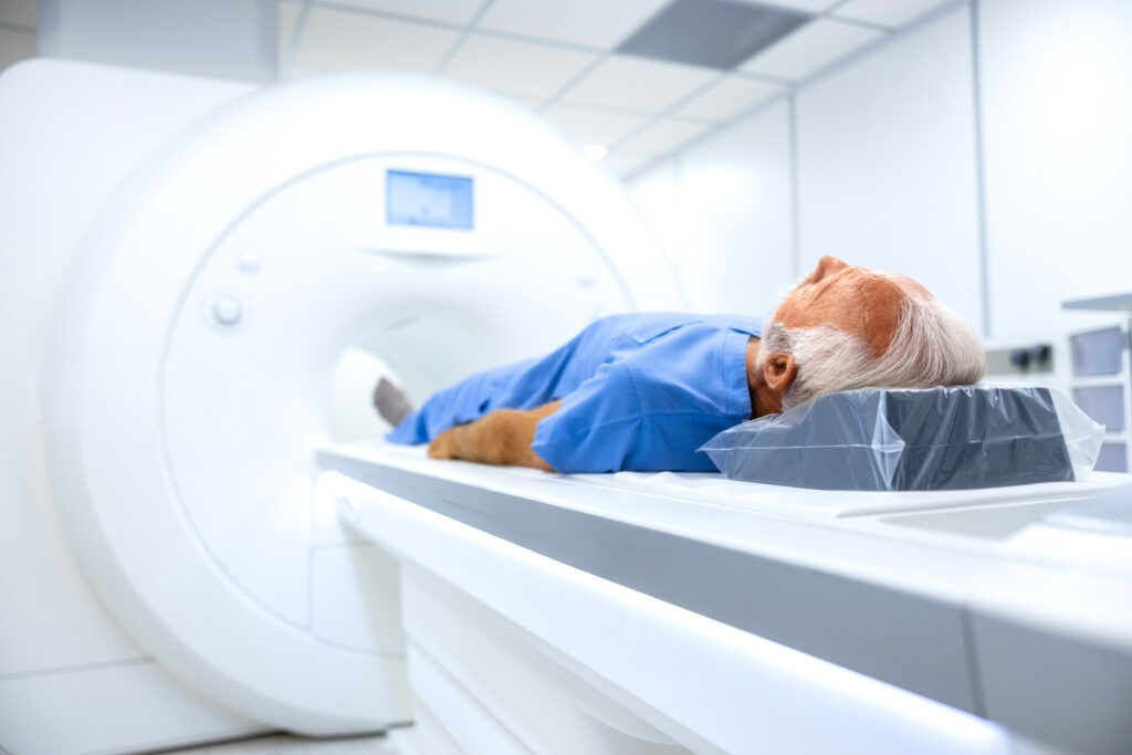 Elderly patient lying on a CT scanner table during a medical imaging exam in a modern diagnostic facility